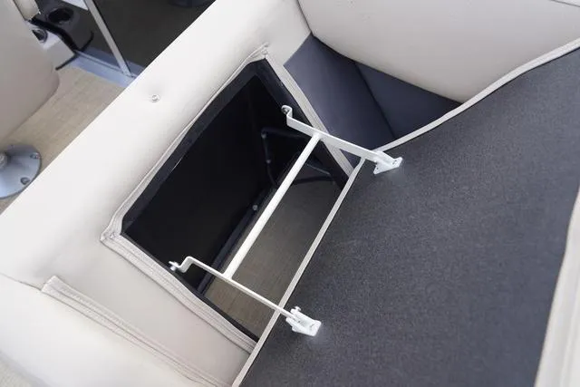 Slide: The Image of 2024 Harris Cruiser 230 CWDH storage compartment with open seat cushion. - 35
