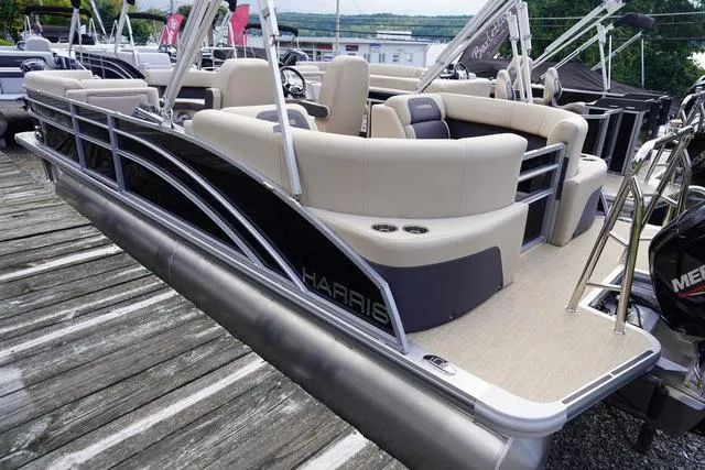 Slide: The Image of 2024 Harris Cruiser 230 CWDH pontoon boat with beige seating, docked on wooden pier. - 4
