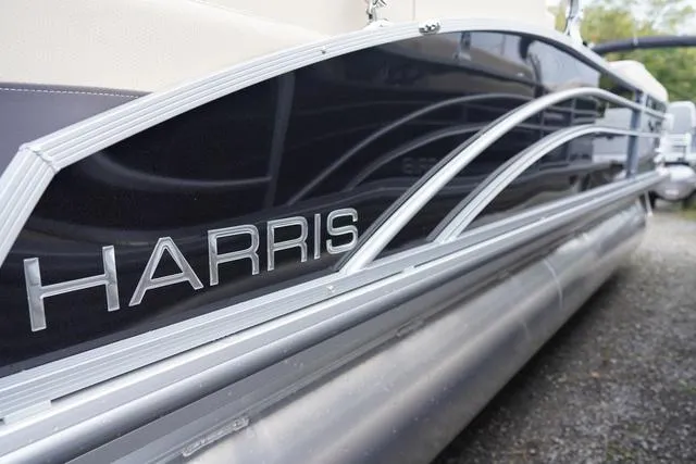 Slide: The Image of 2024 Harris Cruiser 230 CWDH pontoon boat with sleek design and metallic accents. - 7