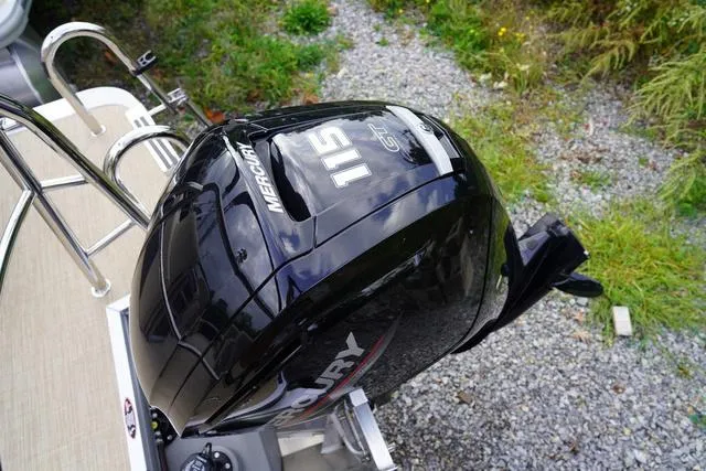 Slide: The Image of 2024 Harris Cruiser 230 CWDH with Mercury 115 outboard engine, parked on gravel. - 8