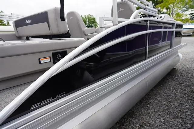 Slide: The Image of 2025 Barletta Boats A22UC pontoon boat, sleek design, silver and black exterior, docked outdoors. - 4