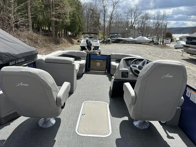 Slide: The Image of 2025 Barletta Boats A22UC interior with gray seating, steering console, and outdoor setting. - 28