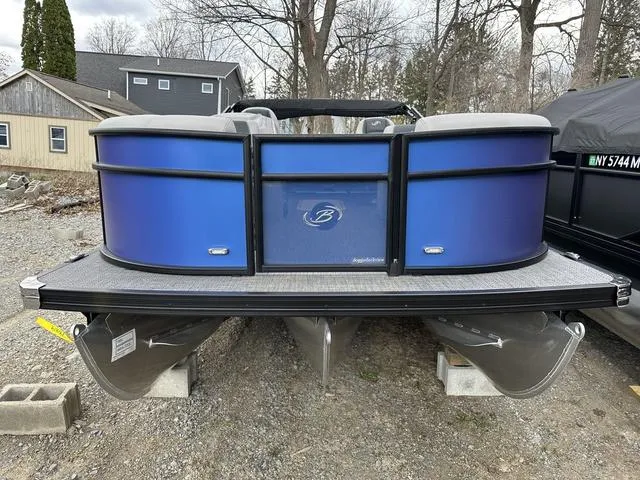 Slide: The Image of 2025 Barletta Boats A22UC pontoon boat with blue exterior, parked on gravel. - 4