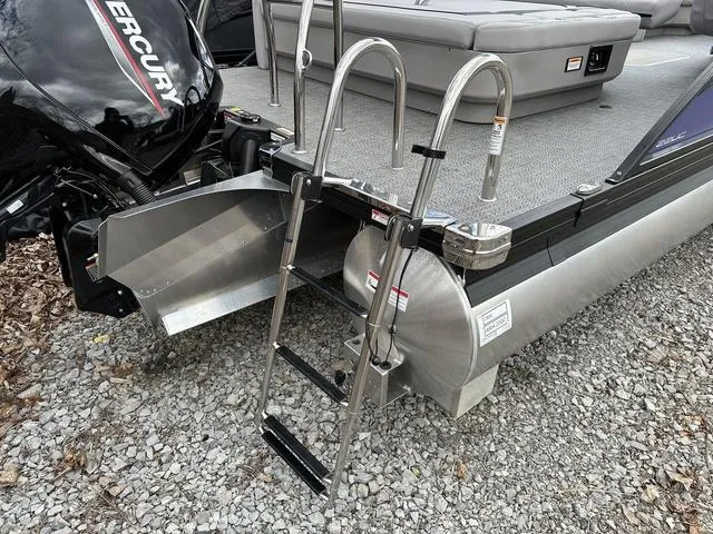 Slide: The Image of 2025 Barletta A22UC boat with ladder and Mercury engine on gravel surface. - 43