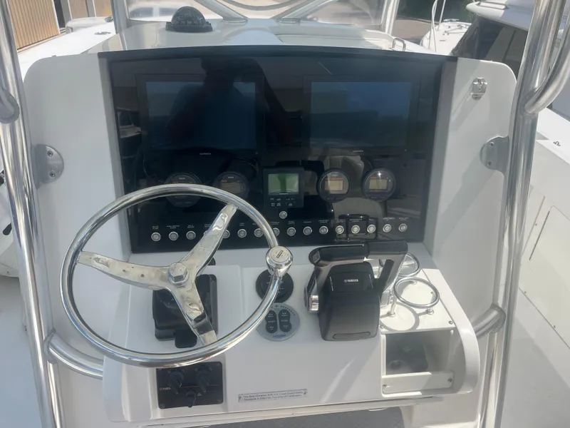 Slide: The Image of 2006 Southport 28 Center Console boat dashboard with steering wheel and control panel. - 11