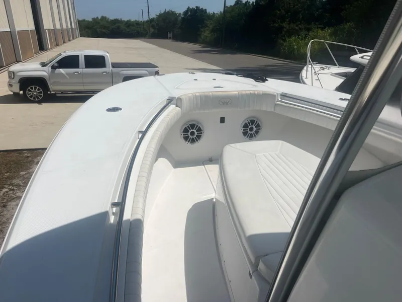 Slide: The Image of 2006 Southport 28 Center Console boat with white seating and speakers, parked near a truck. - 9