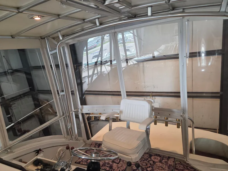 Slide: The Image of 1989 Chris-Craft 42 Sportfish Commander helm with white captain's chair and enclosed cockpit. - 24