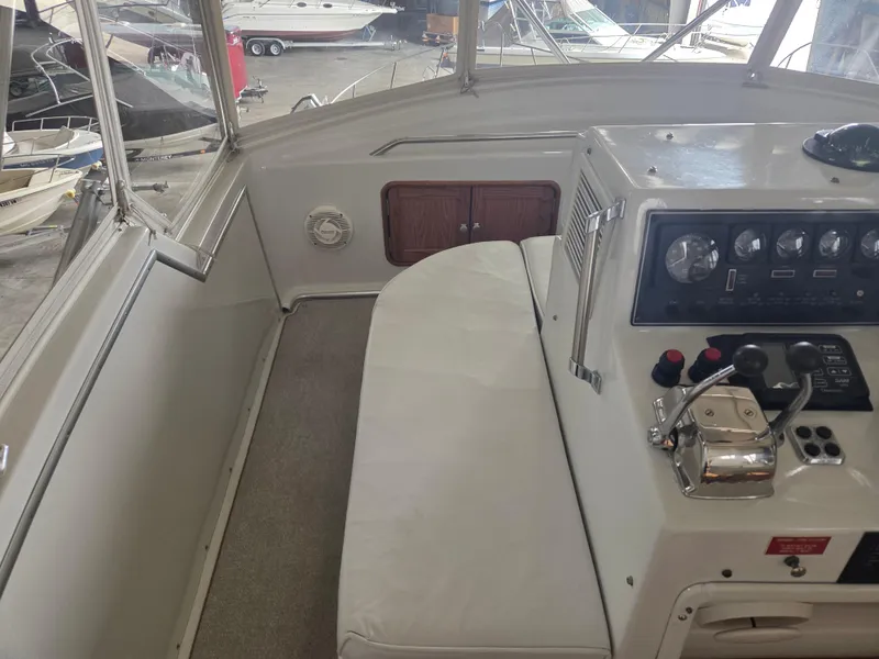 Slide: The Image of 1989 Chris-Craft 42 Sportfish Commander helm with controls and seating in a boatyard. - 27