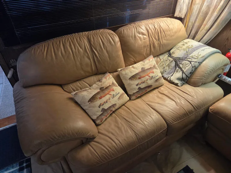 Slide: The Image of Beige leather sofa with fish-themed pillows on a 1989 Chris-Craft 42 Commander Sportfish. - 33