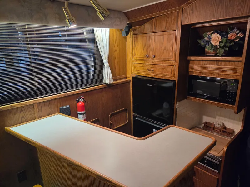Slide: The Image of Interior of 1989 Chris-Craft 42 Sportfish Commander with kitchen area and wooden cabinetry. - 40
