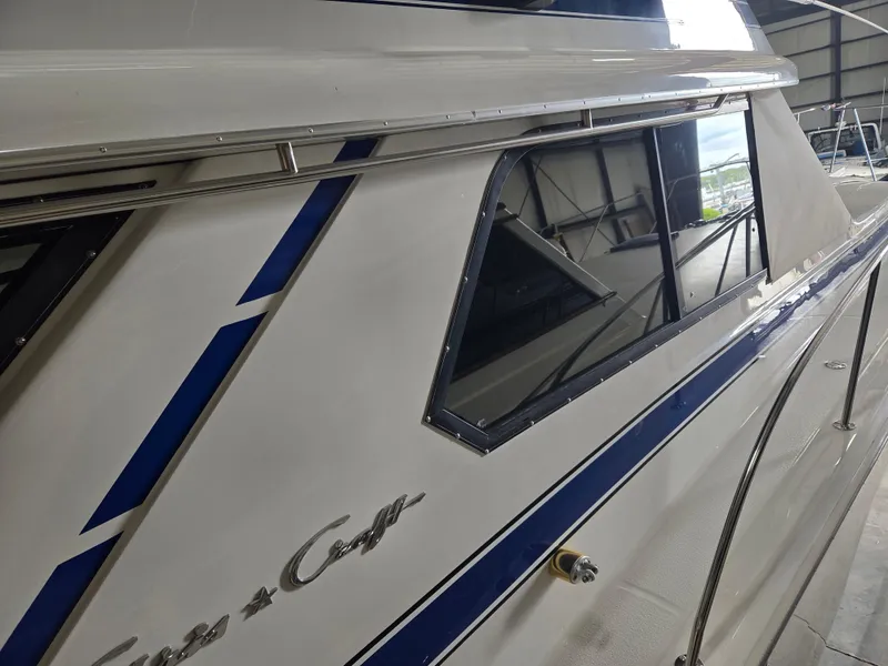 Slide: The Image of 1989 Chris-Craft 42 Sportfish Commander yacht with sleek blue accents in a marina. - 6