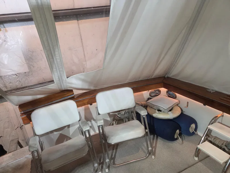Slide: The Image of 1989 Chris-Craft 42 Sportfish Commander interior with white chairs and nautical decor. - 71