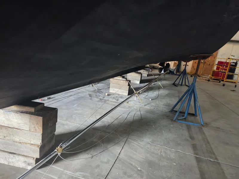 Slide: The Image of 1989 Chris-Craft 42 Sportfish Commander hull supported by blocks and stands in a workshop. - 93