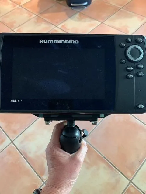 Slide: The Image of Hand holding a Humminbird Helix 7 fish finder, tiled floor background. - 10