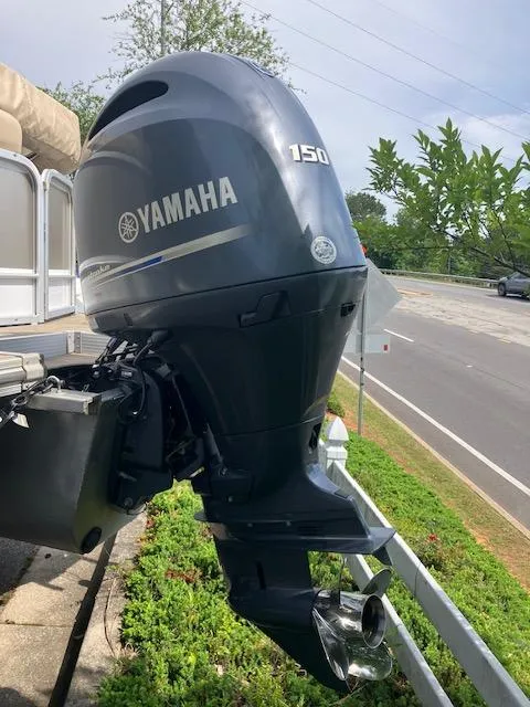 Slide: The Image of 2020 G3 SunCatcher V322FC with Yamaha 150 outboard motor, parked near a road. - 7