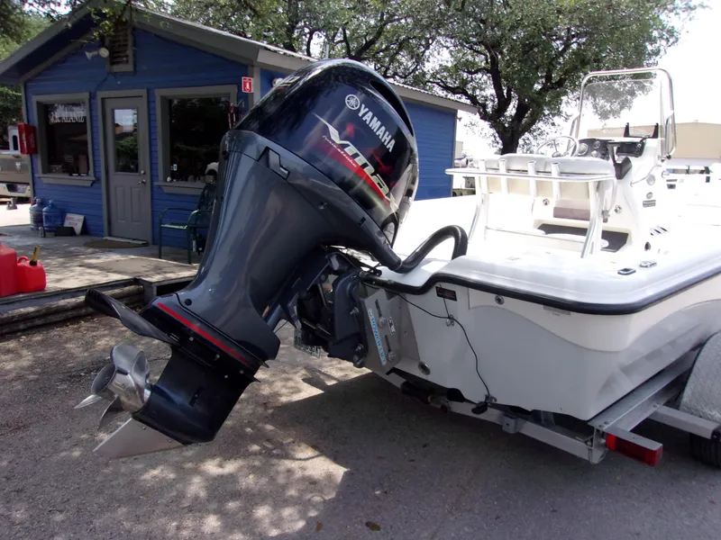 Slide: The Image of Boat with Yamaha outboard motor, Blue Wave 2000 SL, 2018 model, parked near a blue building. - 3