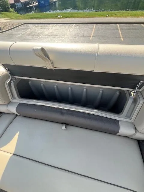 Slide: The Image of 2023 Sun Tracker Party Barge 20 DLX storage compartment with open seat cushion. - 10