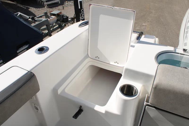 Slide: The Image of 2024 Sea Pro 240 boat storage compartment with open lid and cup holder. - 10