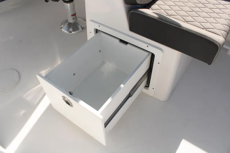 Slide: The Image of 2024 Sea Pro 240 boat interior with open storage drawer and cushioned seating. - 15