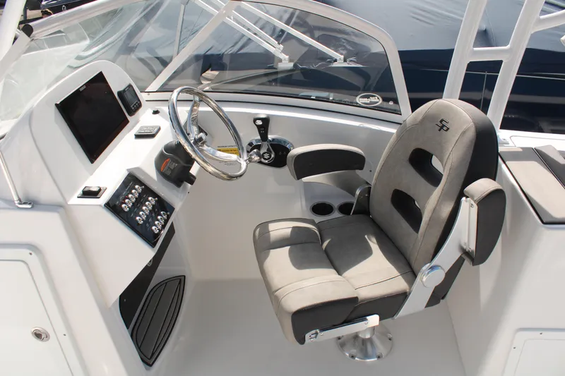 Slide: The Image of 2024 Sea Pro 240 boat cockpit with steering wheel and comfortable captain's chair. - 18