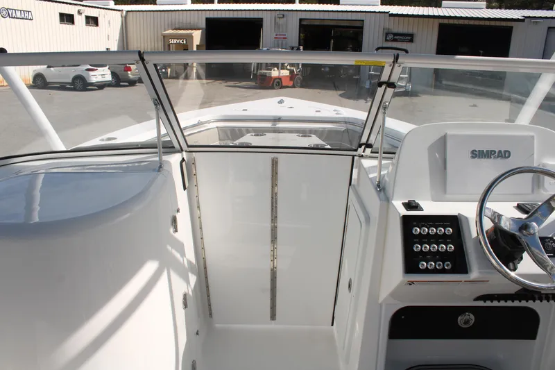 Slide: The Image of 2024 Sea Pro 240 boat cockpit with steering wheel and Simrad display. - 32