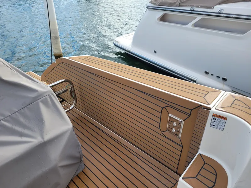 Slide: The Image of 2021 Tiara Sport 43LE boat with teak deck, docked on calm water. - 16