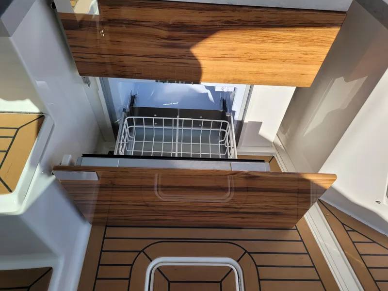 Slide: The Image of 2021 Tiara Sport 43LE interior with wooden cabinetry and open storage compartment. - 17