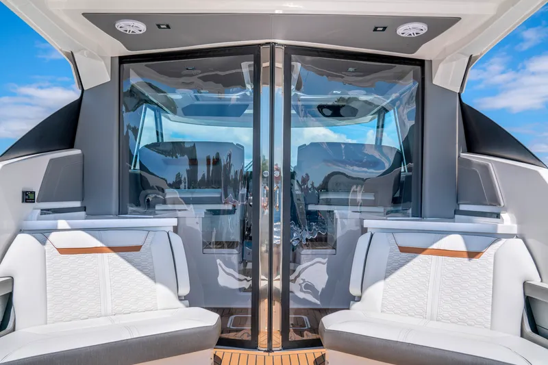 Slide: The Image of 2021 Tiara Sport 43LE yacht interior with luxurious seating and glass doors. - 18