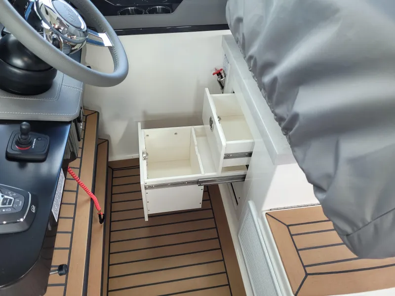 Slide: The Image of 2021 Tiara Sport 43LE helm with open storage drawers and teak flooring. - 23