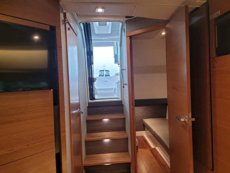 Slide: The Image of Interior view of 2021 Tiara Sport 43LE yacht, featuring wooden stairs and modern design. - 24