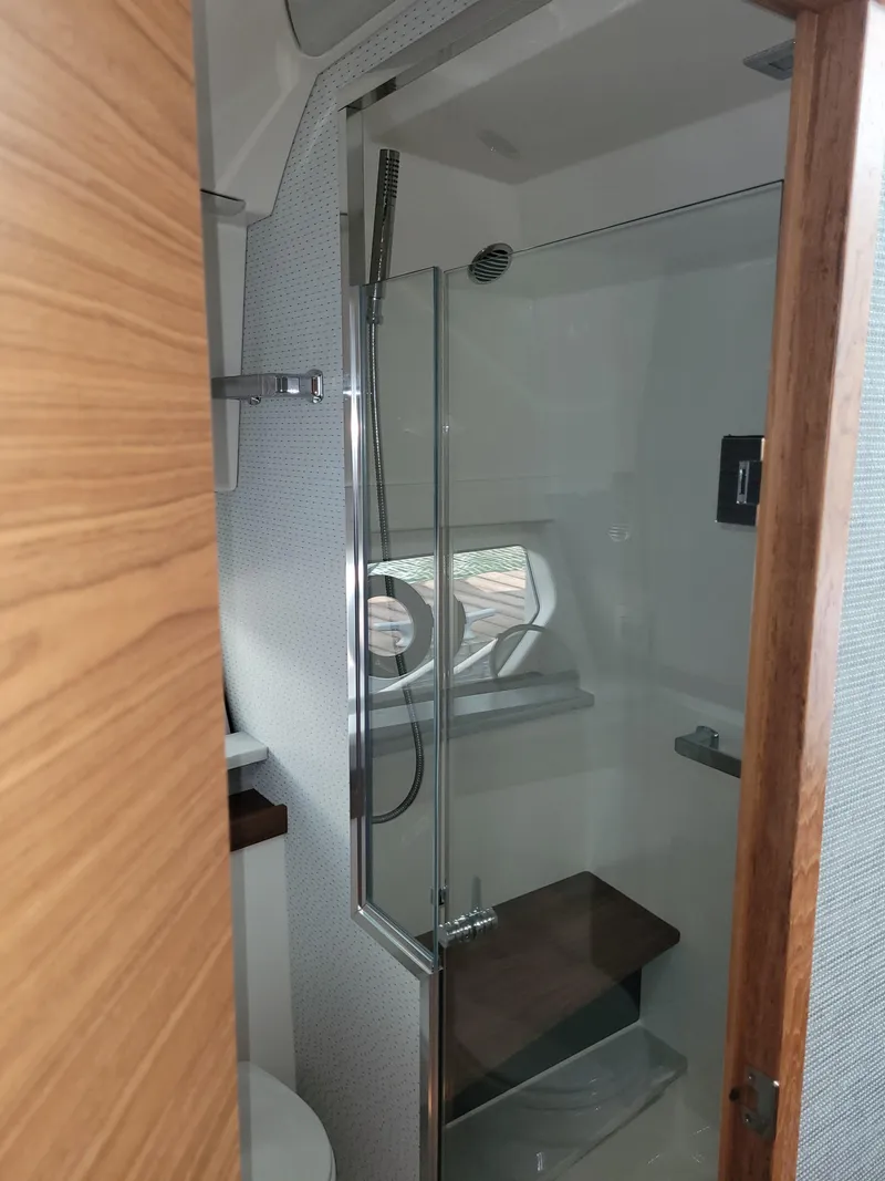 Slide: The Image of 2021 Tiara Sport 43 LE yacht bathroom with glass shower and wooden accents. - 36