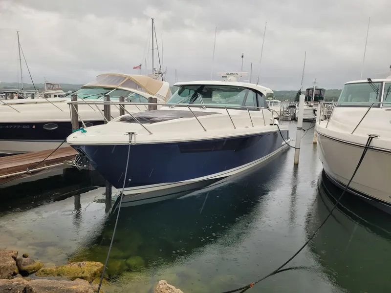 Slide: The Image of 2021 Tiara Sport 43LE boat docked in a marina on a cloudy day. - 4