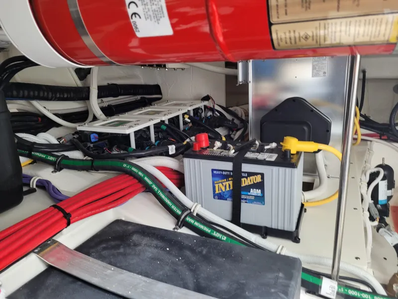 Slide: The Image of 2021 Tiara Sport 43LE engine compartment with battery and wiring. - 46