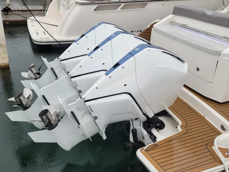 Slide: The Image of Triple outboard engines on a 2021 Tiara Sport 43LE boat, docked with teak decking. - 6