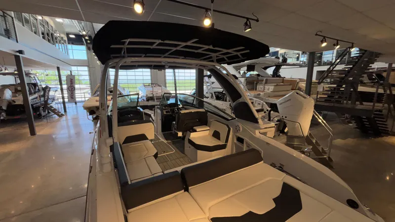 Slide: The Image of 2025 Monterey 298 Super Sport boat interior in showroom, featuring sleek seating and modern design. - 7