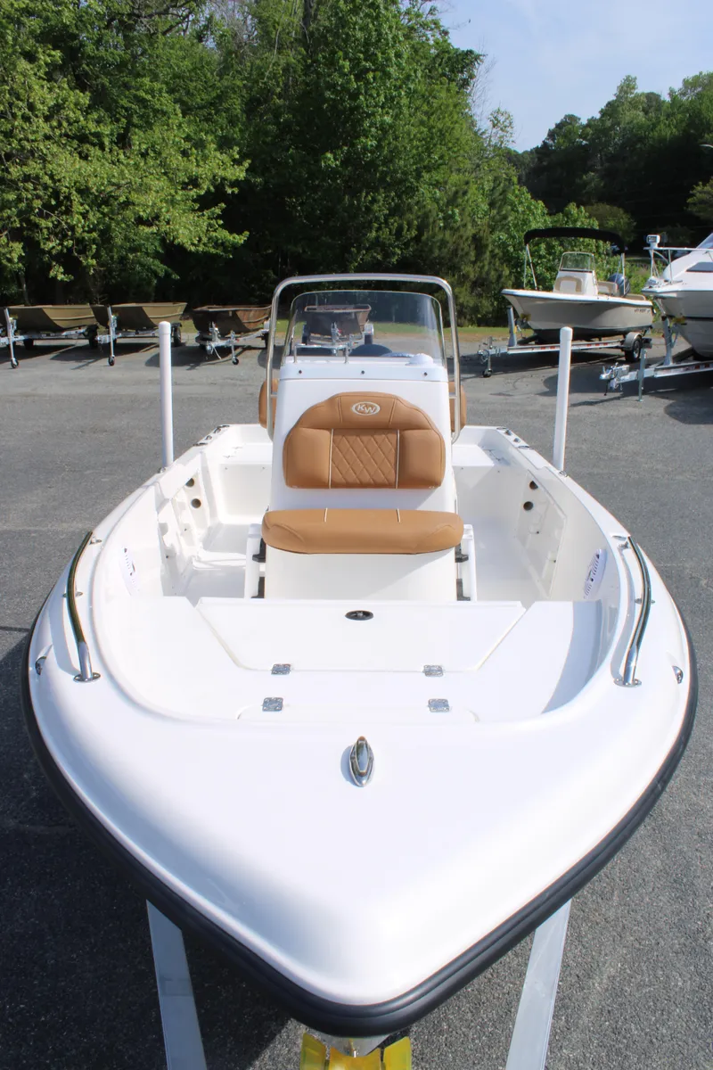 Slide: The Image of 2025 Key West 1720 Center Console boat with tan seating, parked outdoors. - 13