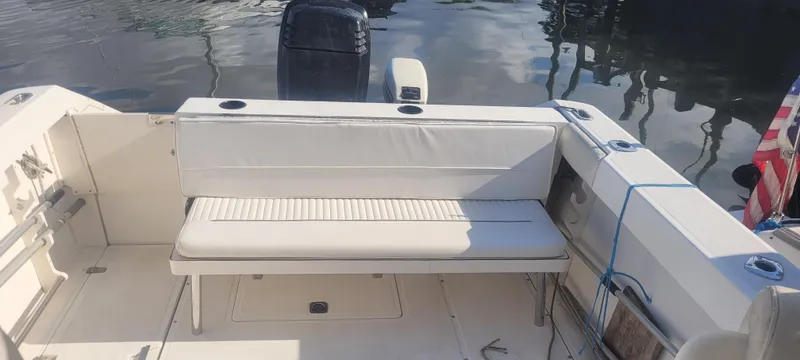 Slide: The Image of 1999 Boston Whaler 23 Conquest boat interior with seating and outboard motor. - 13