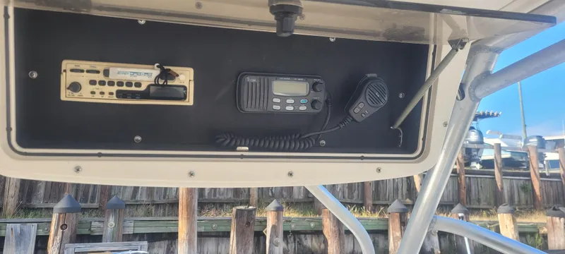 Slide: The Image of 1999 Boston Whaler 23 Conquest boat dashboard with radio and communication equipment. - 14