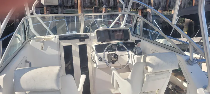 Slide: The Image of 1999 Boston Whaler 23 Conquest boat interior with steering wheel and seating. - 15