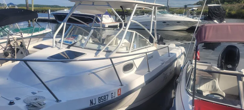 Slide: The Image of 1999 Boston Whaler 23 Conquest boat docked among other vessels. - 18