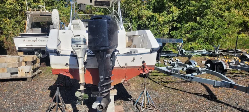 Slide: The Image of 1999 Boston Whaler 23 Conquest boat on stands, with visible outboard motors and trailer. - 5