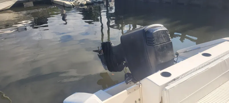 Slide: The Image of 1999 Boston Whaler 23 Conquest boat with outboard motor at dock. - 7