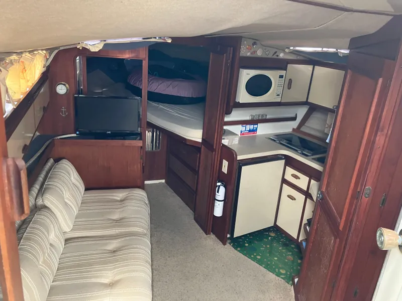 Slide: The Image of 1985 Cruisers 336 Ultra Vee interior with kitchenette, sofa, and sleeping area. - 17