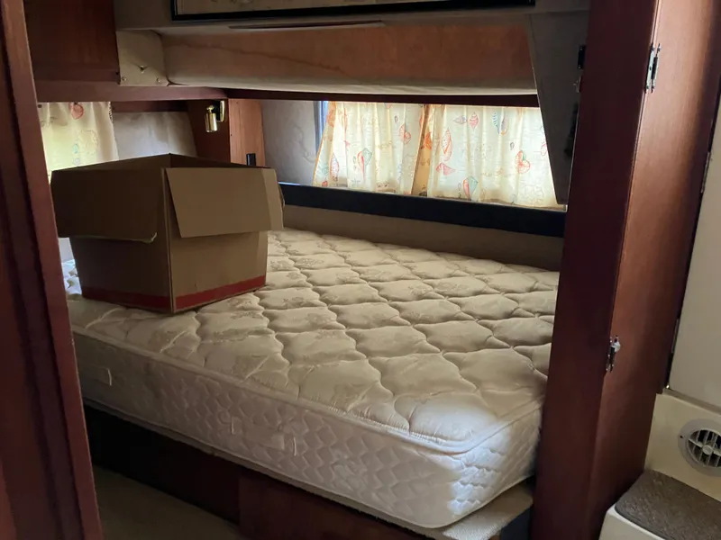 Slide: The Image of 1985 Cruisers 336 Ultra Vee cabin interior with bed and cardboard box. - 18