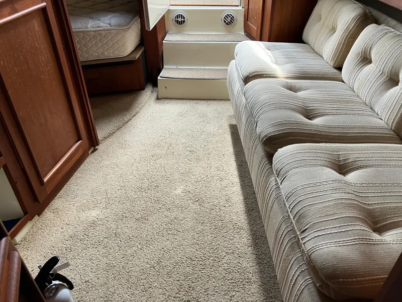 Slide: The Image of Interior of 1985 Cruisers 336 Ultra Vee with beige carpet and striped sofa. - 26