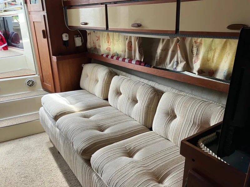 Slide: The Image of Interior of 1985 Cruisers 336 Ultra Vee with beige sofa and wooden cabinetry. - 27