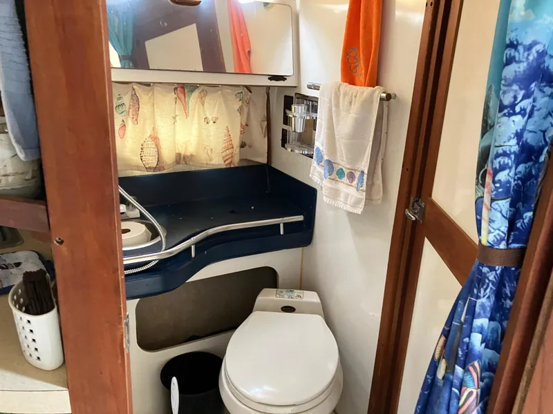 Slide: The Image of 1985 Cruisers 336 Ultra Vee boat bathroom with sink, toilet, and nautical-themed decor. - 28