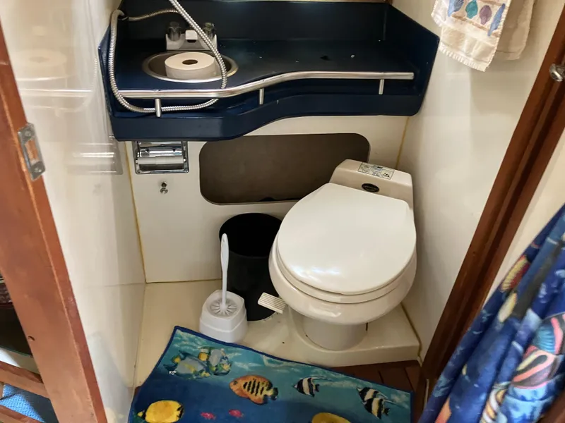 Slide: The Image of 1985 Cruisers 336 Ultra Vee boat bathroom with sink, toilet, and marine-themed decor. - 30