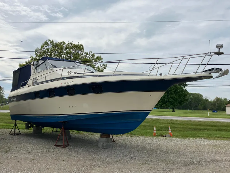 Slide: The Image of 1985 Cruisers 336 Ultra Vee boat on stands, displayed outdoors on gravel. - 6