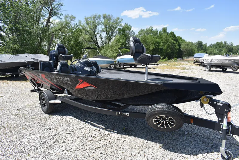 Slide: The Image of 2025 Lund 1875 Renegade SS boat on trailer, parked outdoors on gravel. - 1